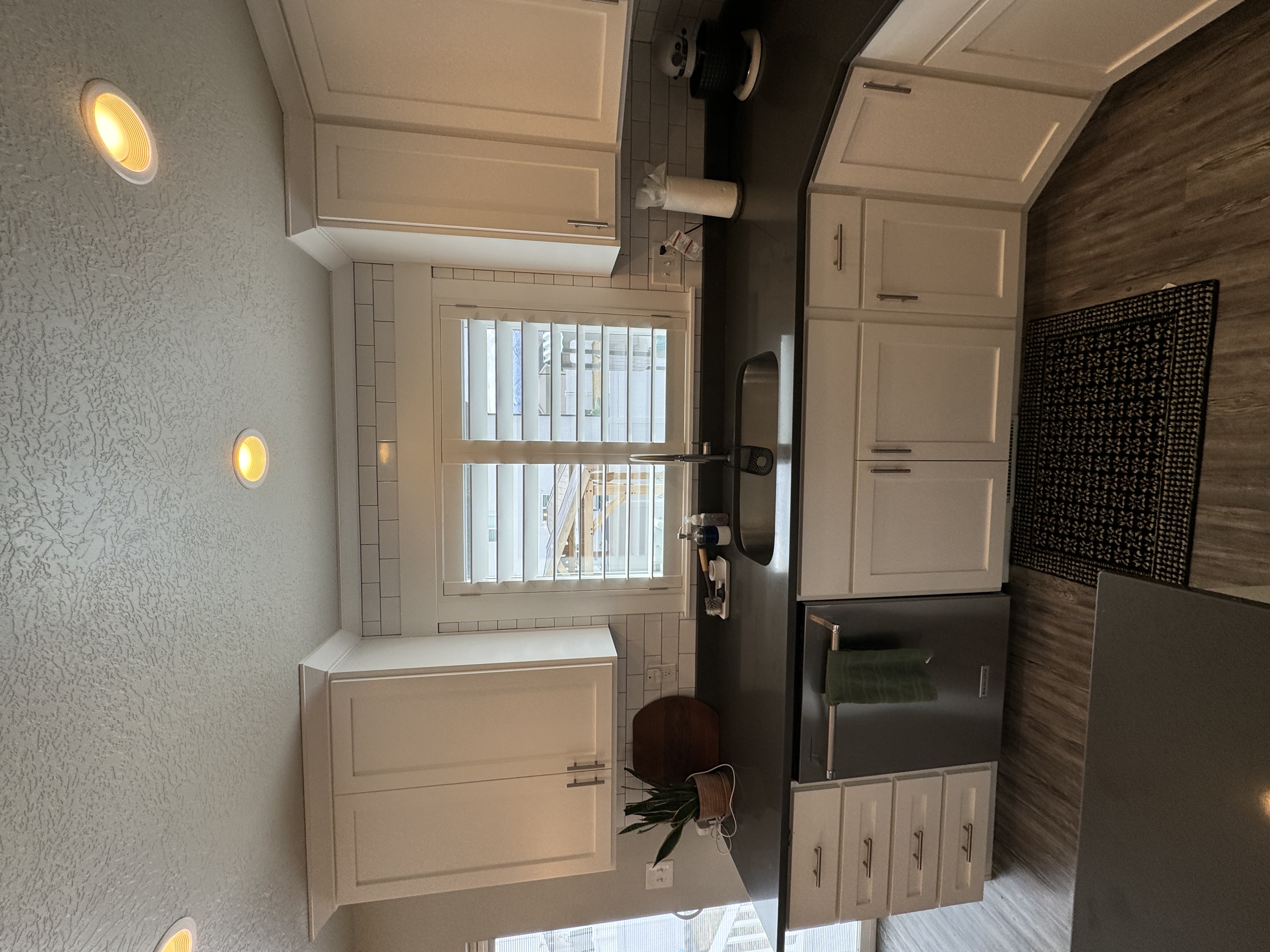 Kitchen shutters over sink with subway tile